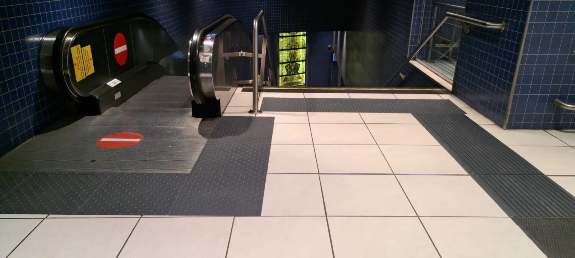 Kunststof noppentegels en geleidelijn voor een roltrap.
