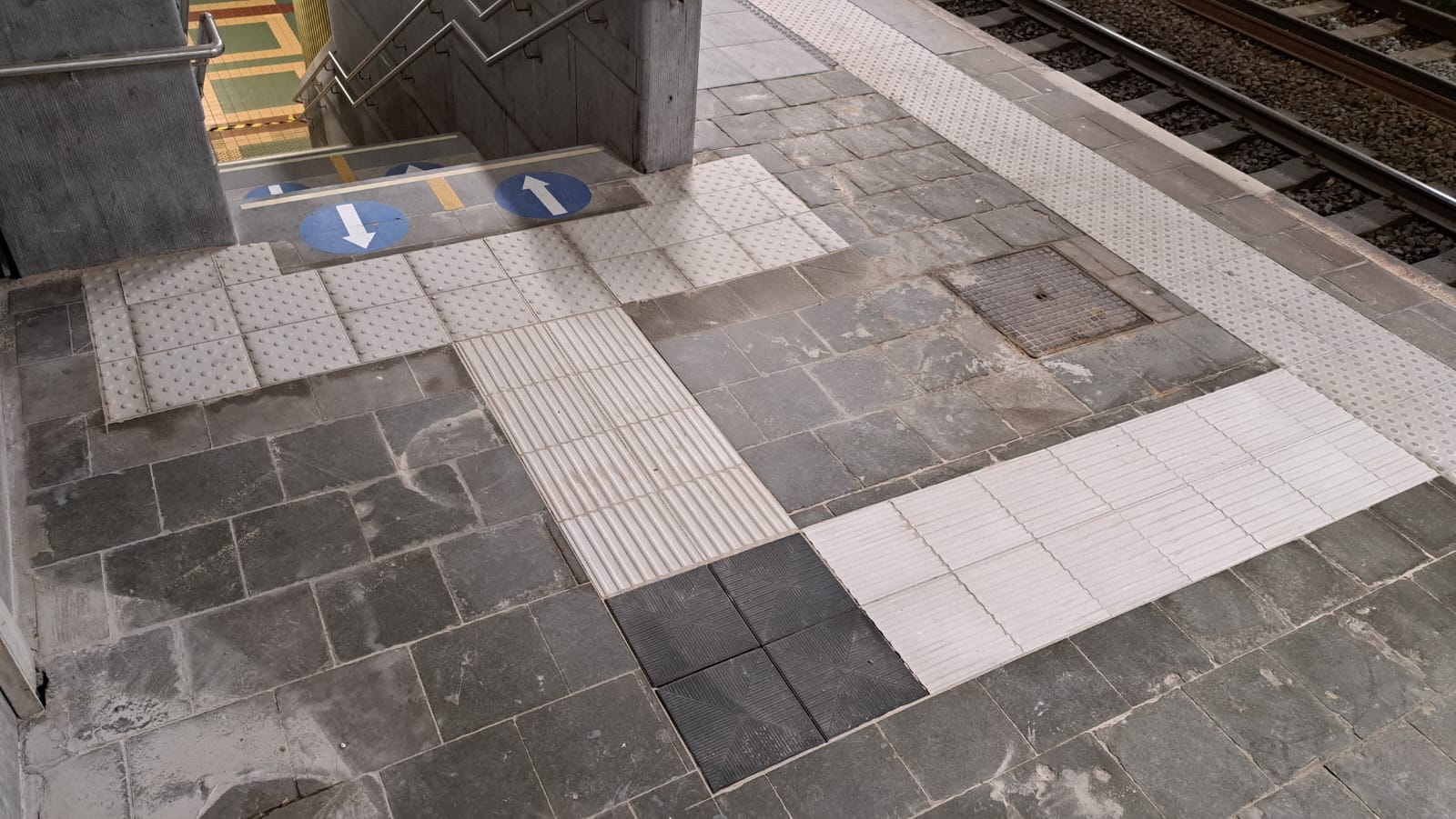Geleidetegels en waarschuwingsindicatoren in beton op een treinperron in Brussel-Noord.