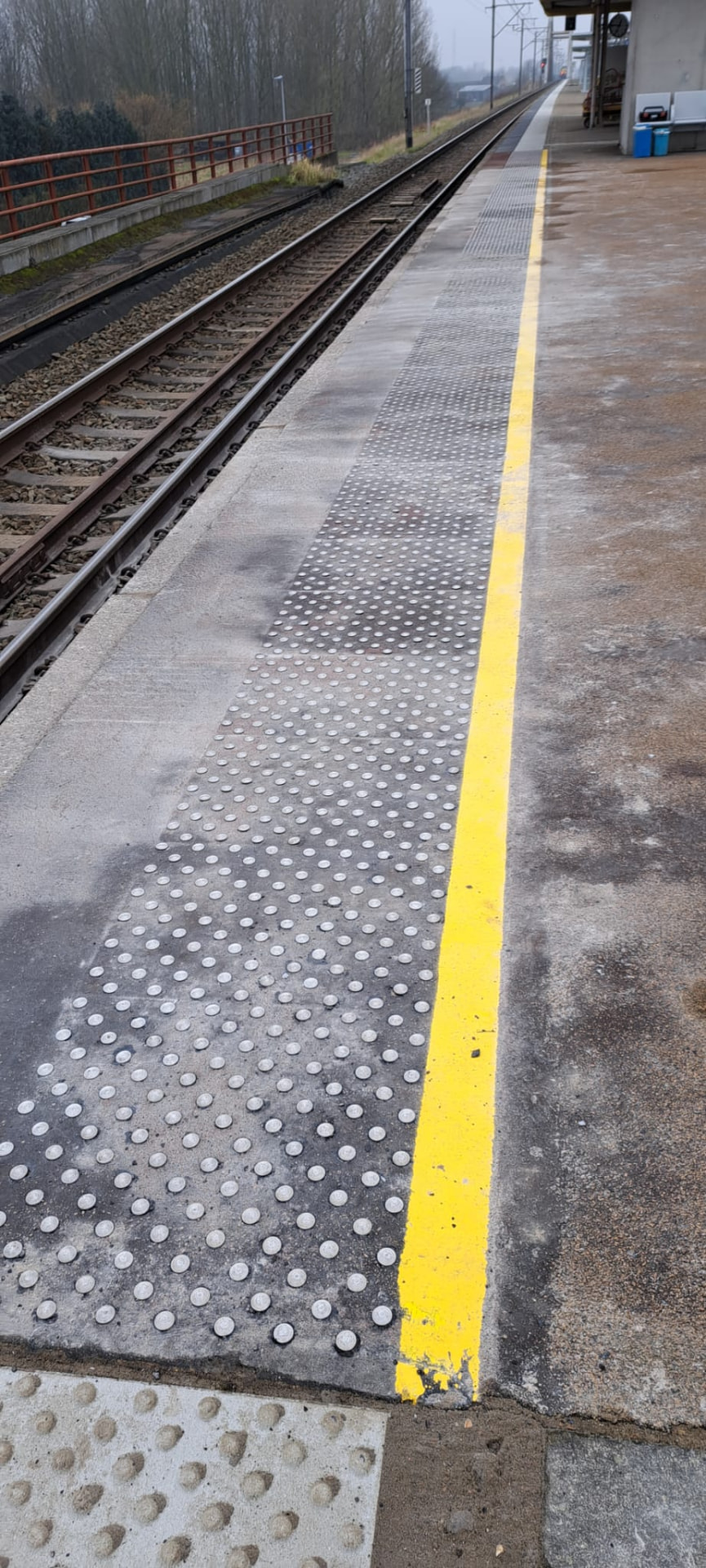 Metalen noppen in de rand van een treinperron.